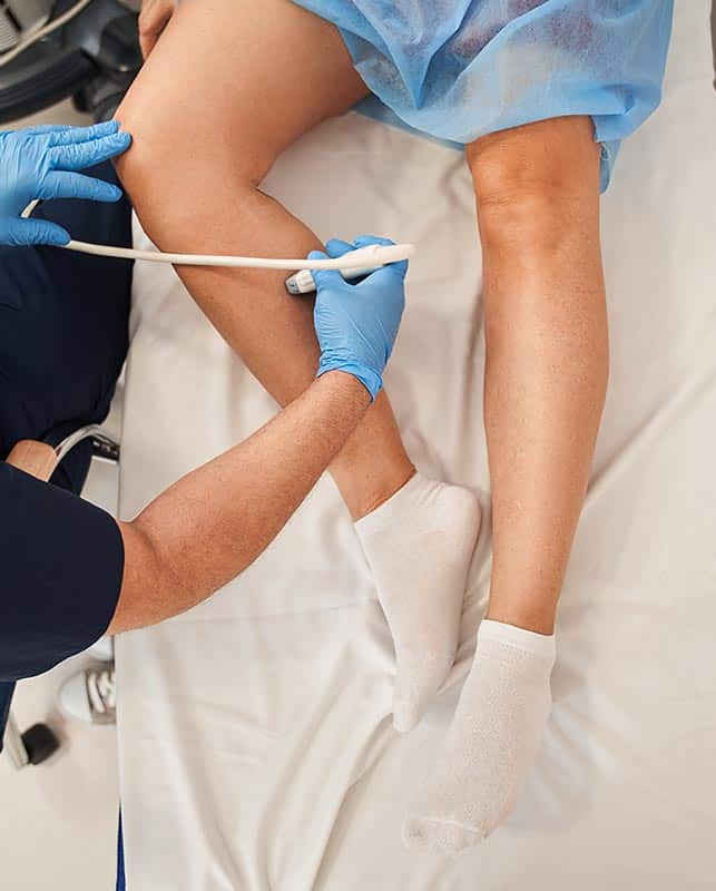 Doctor Treating Veins on a Patient's Leg