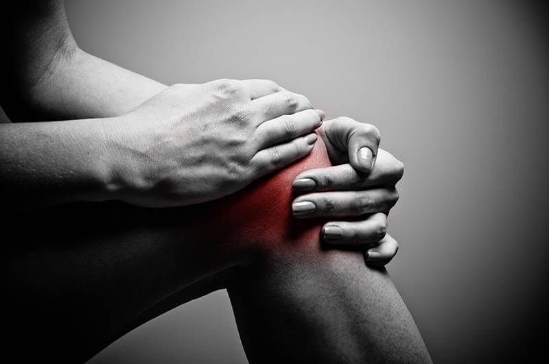 Person holding their knee in pain